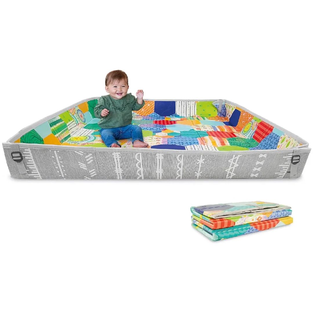 Child playing on a colorful Infantino  play mat with a folded mat beside it on a white background