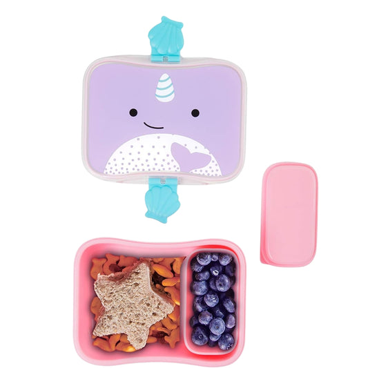 A children's Skip Hop lunch box set on a white background, featuring a lavender unicorn-themed lid with a turquoise clip, a pink divided tray filled with food, and a separate pink lid.