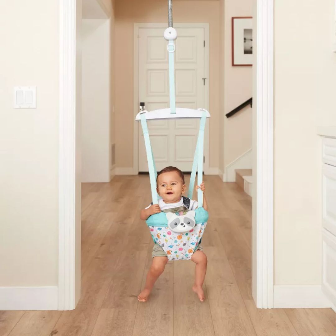Baby in a colorful baby jumper in a home setting