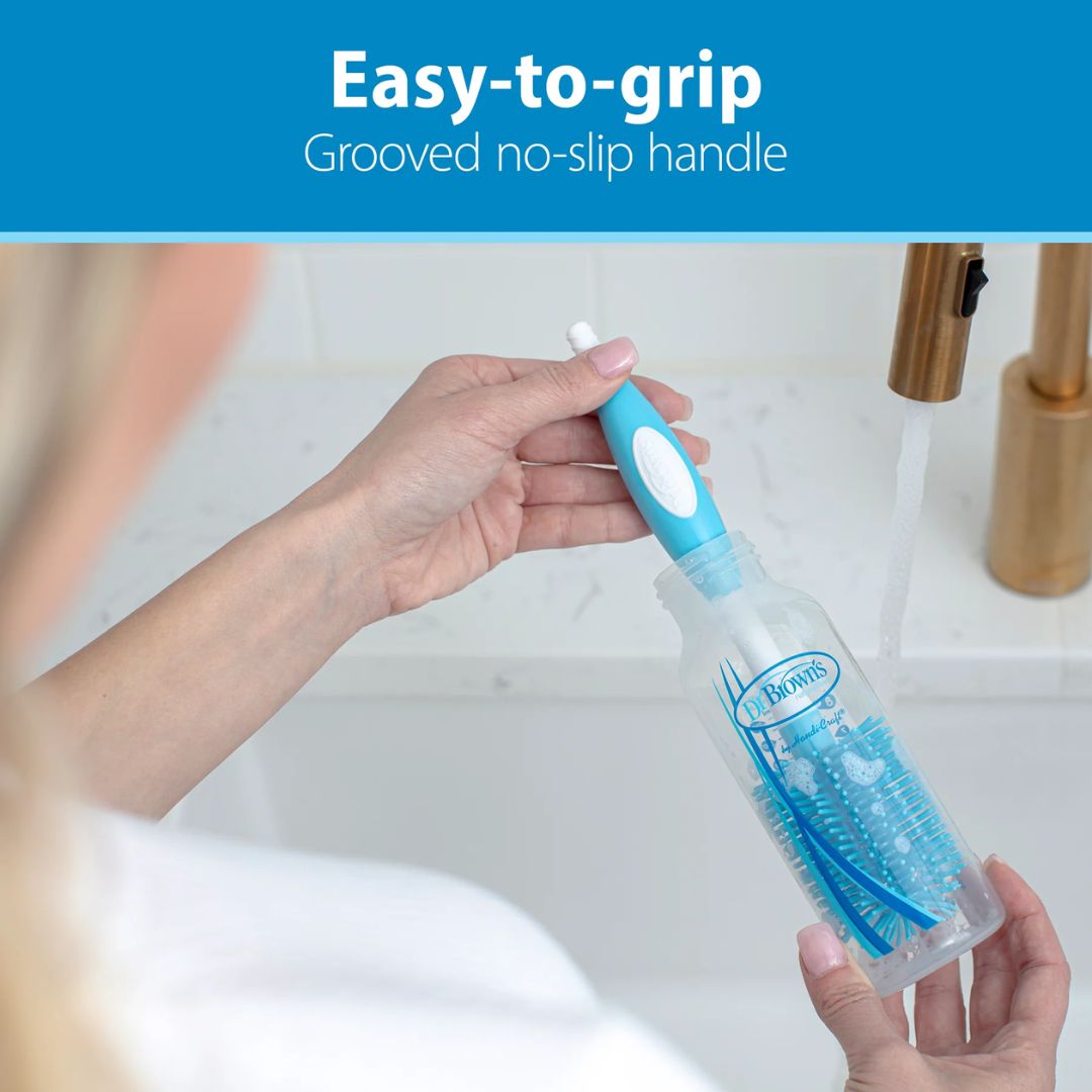 Person holding a cleaning brush with an easy-to-grip handle in a bathroom setting.