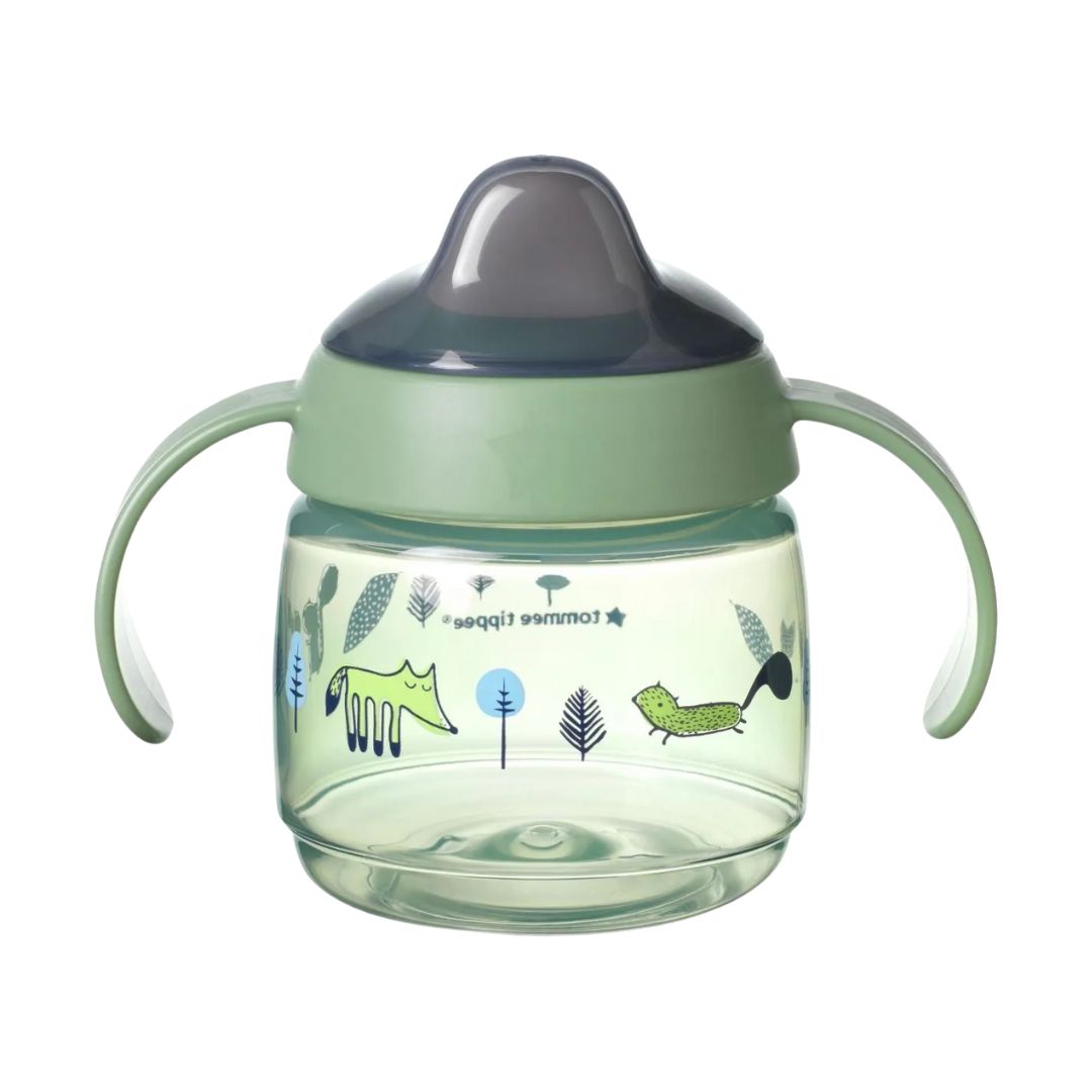 Green Tommee tippee sippy cup with dinosaur illustrations on a white background