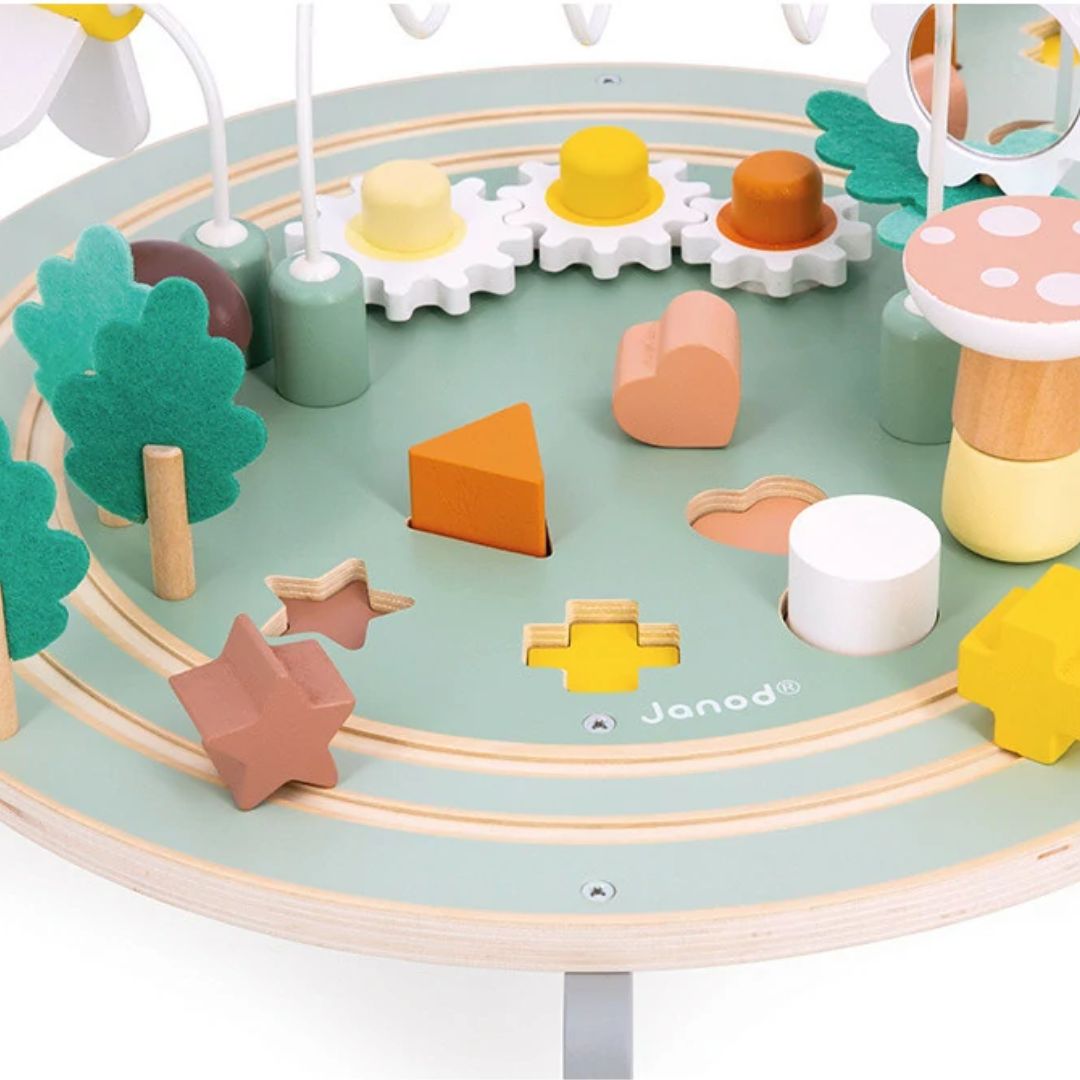 Colorful wooden shape sorter toy with trees and flowers on a circular activity table