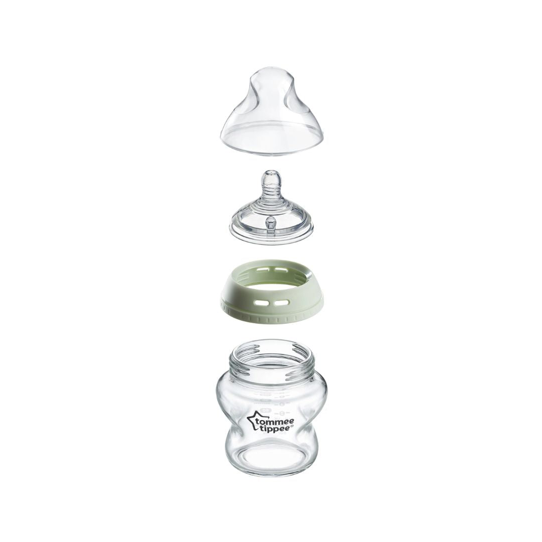 Baby bottle parts including a nipple, teat, and bottle body on a white background
