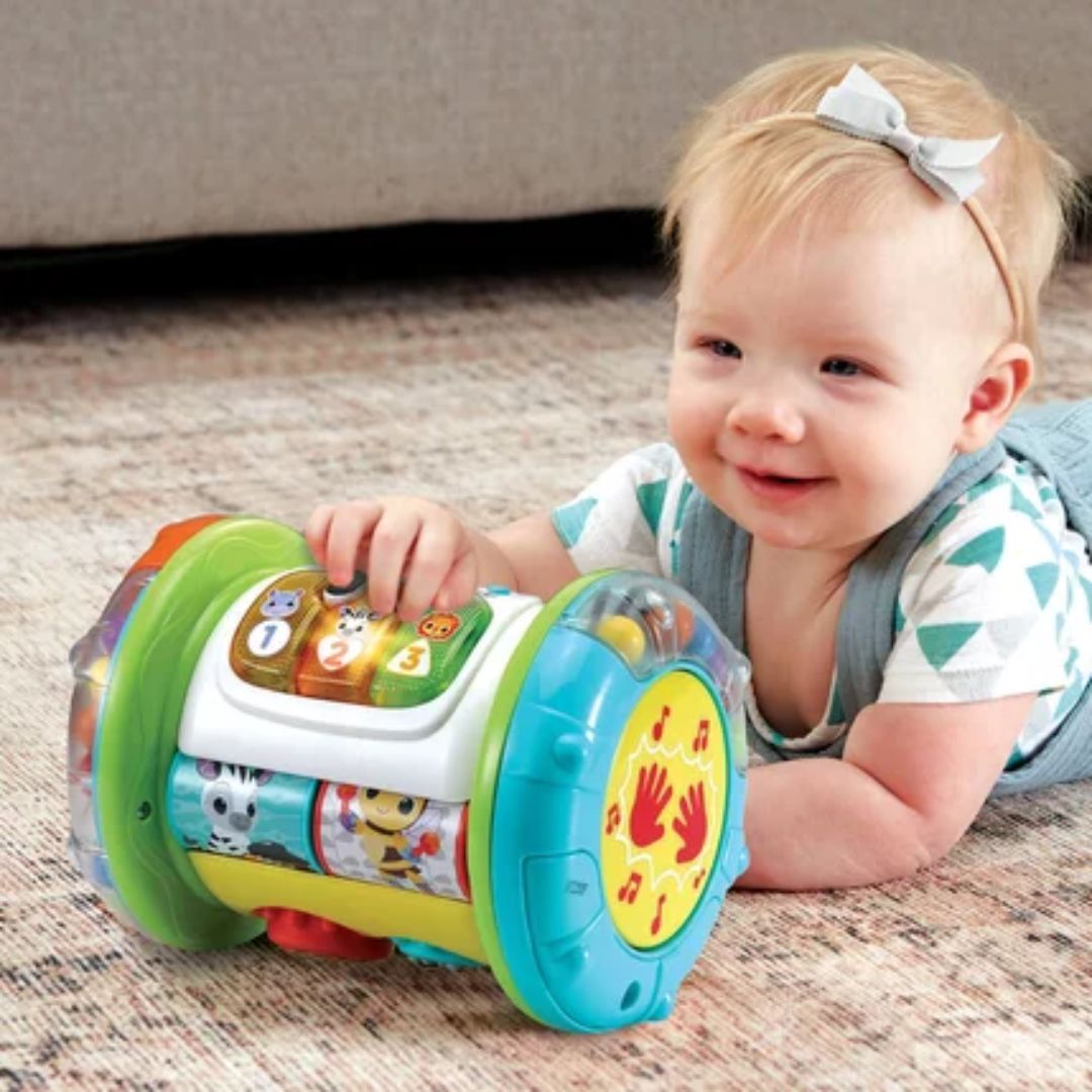 Baby playing with a colorful Vtech toy on a carpeted floor