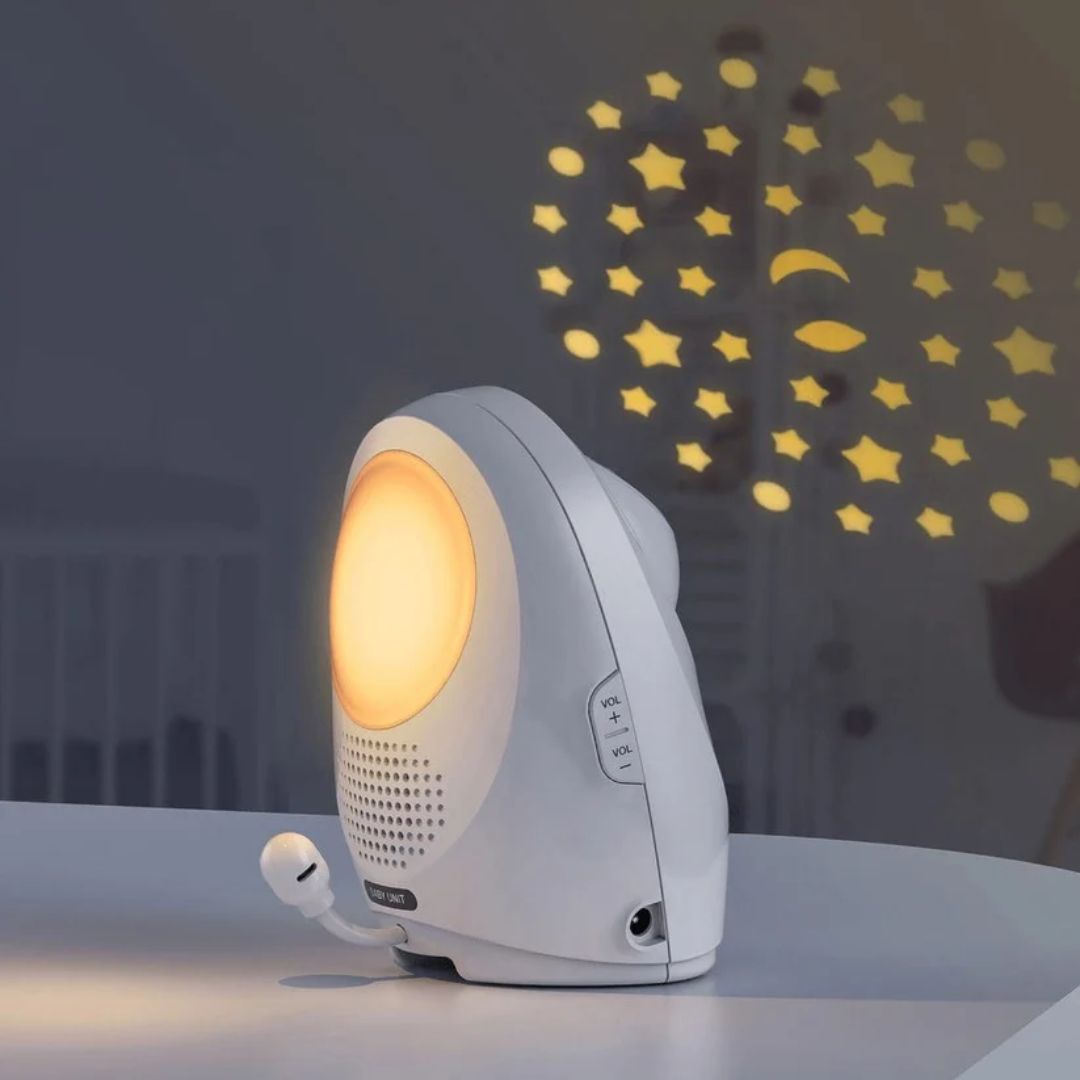 White night light projector with star and moon patterns on a dark wall