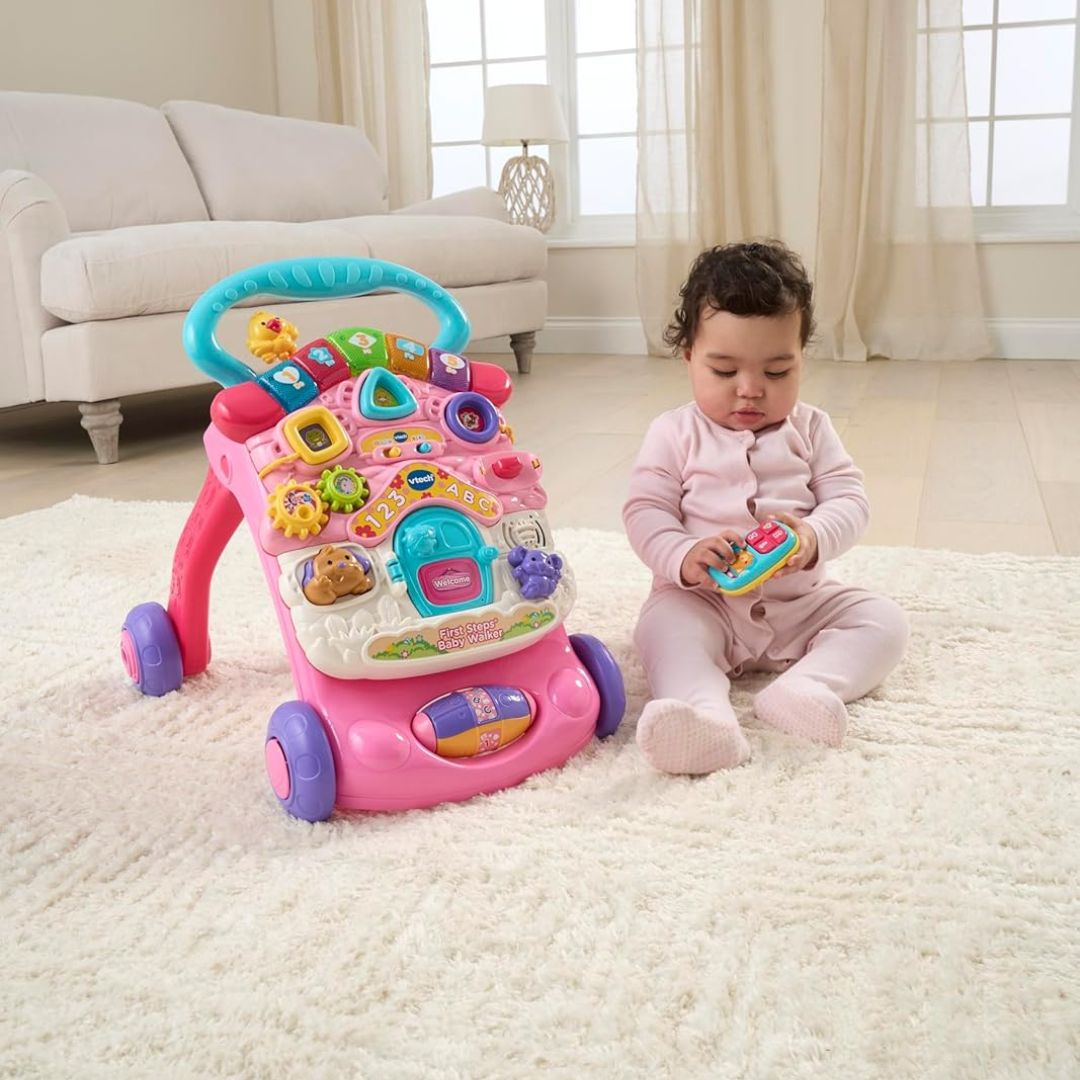 A baby playing with her vtech interactive pink walker on the living room