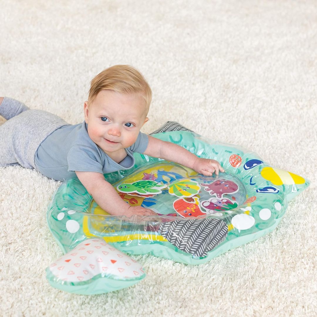 Baby playing with an inflatable water play mat on a carpeted floor