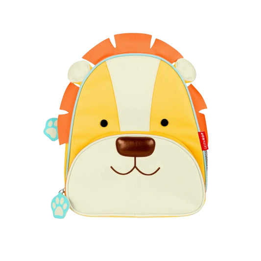 A Skip Hop Lion-themed backpack designed for toddlers, featuring a playful lion face with a yellow and cream body, orange mane, and a small blue paw print zipper pull on a white background.