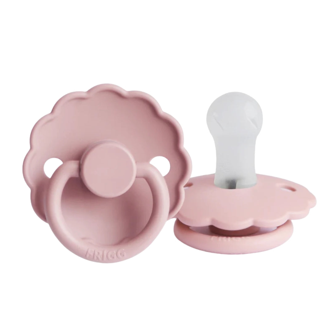 Frigg pink baby pacifiers on a white background