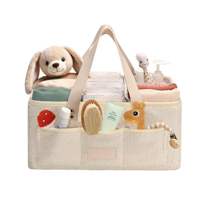 Little Baby Beige diaper bag with plush toys and baby items on a white background