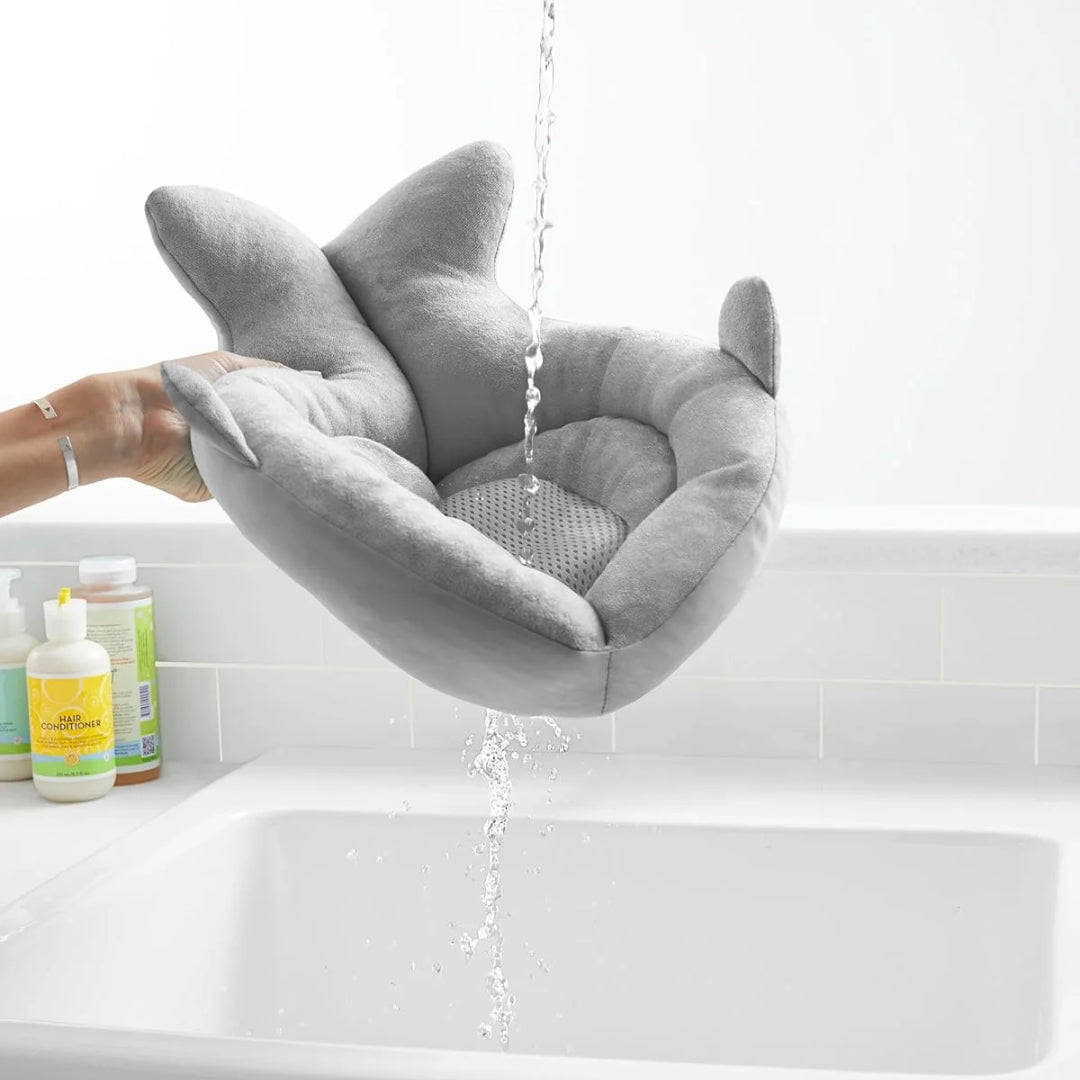 Miila Gray shark-shaped bath seat in a bathtub with water running over it