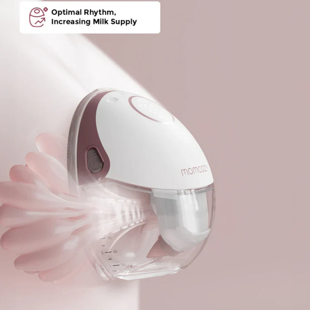 White and red breast pump with 'momcozy' branding on a pink background