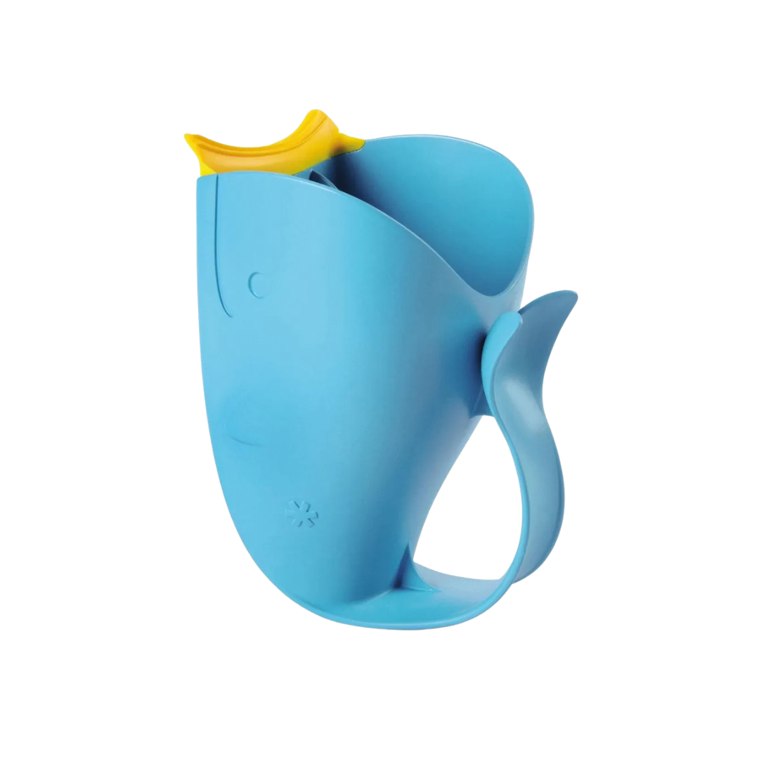 Skip Hop Blue whale-shaped bath rinser cup with a yellow tail fin handle and spout, designed for rinsing a baby's hair during bath time, shown on a white background.