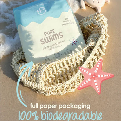 Pure Swims packaging on a beach with a starfish, sand, and water droplets.