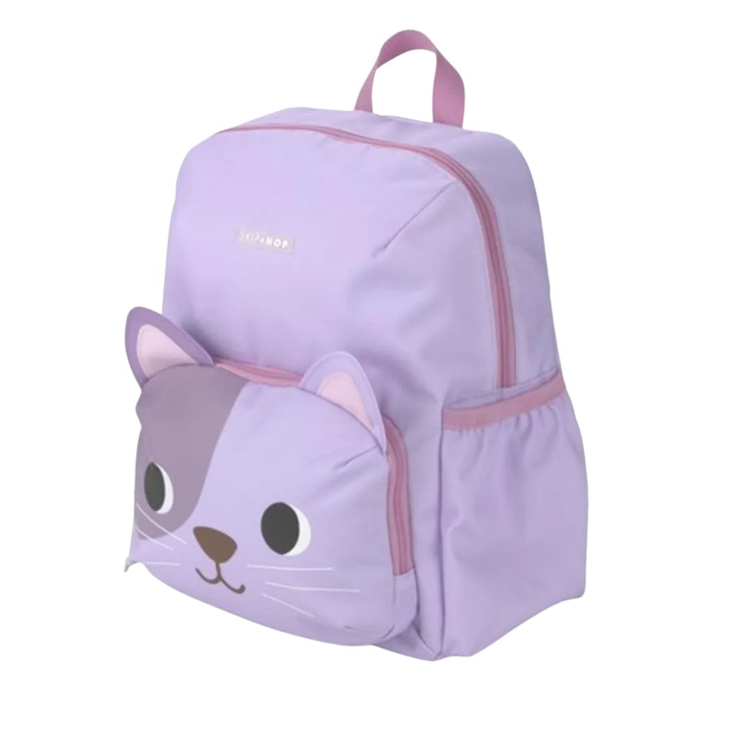 A light purple children's Skip Hop backpack with a cat face design on the front pocket, featuring pink zippers and a top handle, shown on a plain white background.