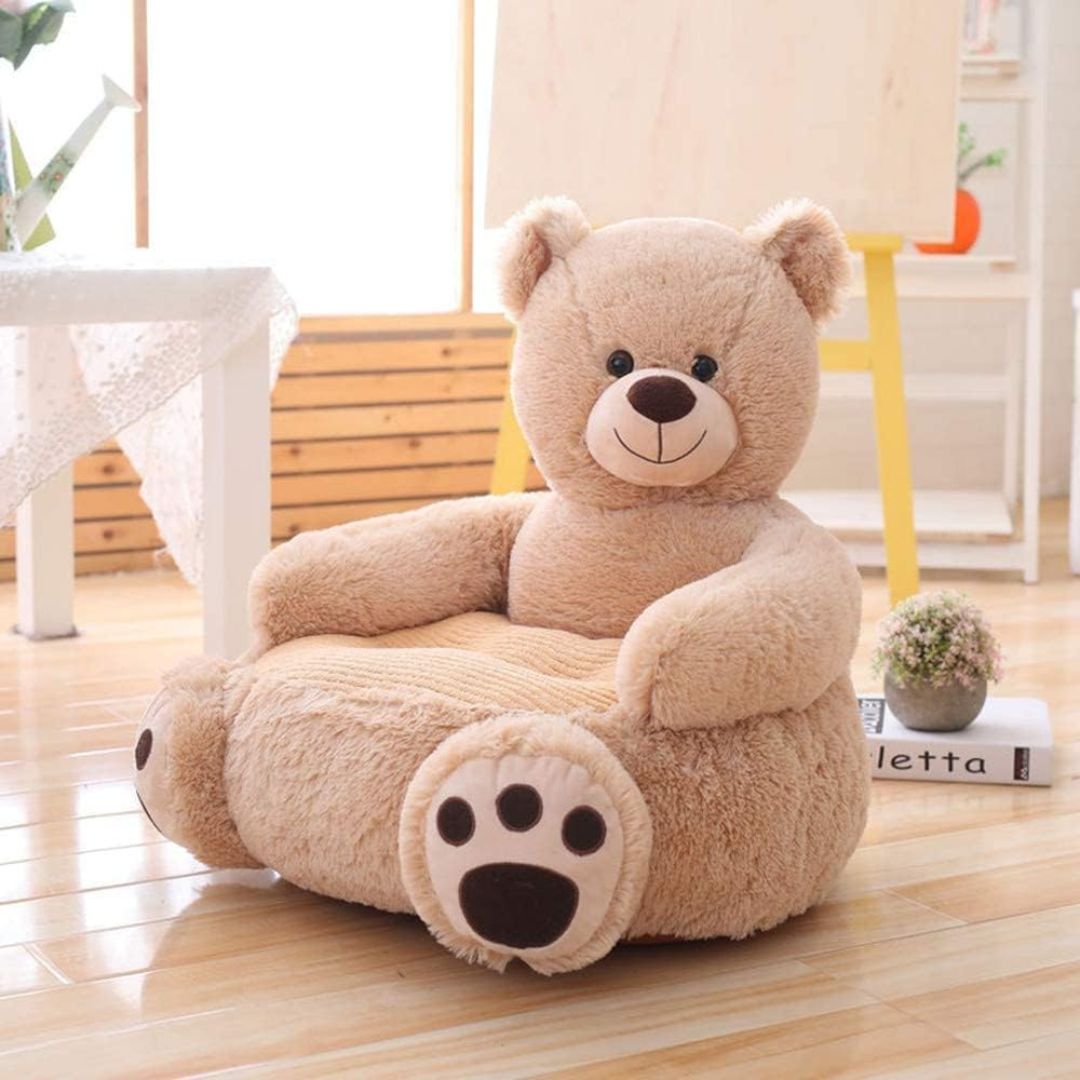 Little Baby Beige teddy bear-shaped chair on a wooden floor with a blurred background