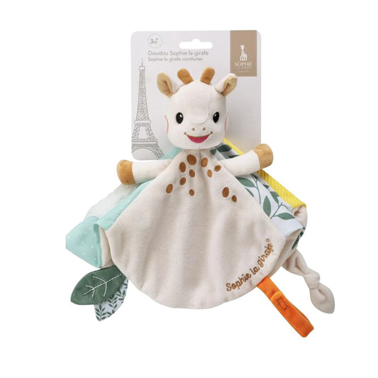 Sophie la Girafe plush comforter in retail packaging, a soft blanket toy with a giraffe head and patterned corners in mint, yellow, and leaf print, labeled 3 months and up.