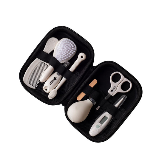 tommee tippee Set of baby care tools including a comb, brush, scissors, and measuring device in a black case on a white background.