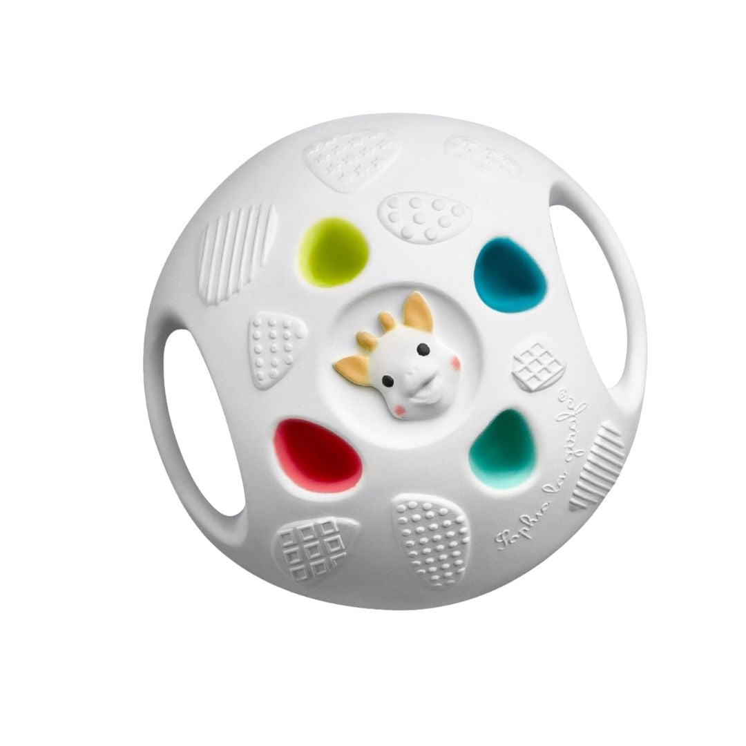 Sophie la Girafe Senso Ball, a white sensory ball with a small giraffe head in the center, surrounded by colorful textured panels in green, red, blue, and teal, and side handles for grip.