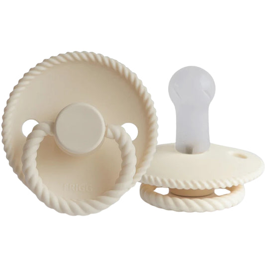 Frigg beige pacifiers with textured design on a white background