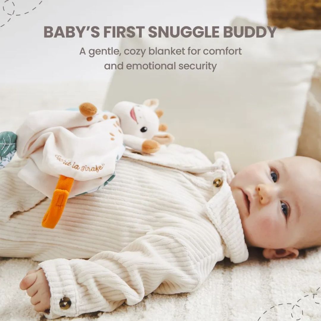 A baby in a cream corduroy outfit lying on a blanket next to the Sophie la Girafe comforter, with text reading 'Baby's First Snuggle Buddy: A gentle, cozy blanket for comfort and emotional security.