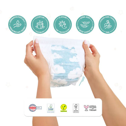 Hands holding a package of baby wipes with various certification logos on a white background