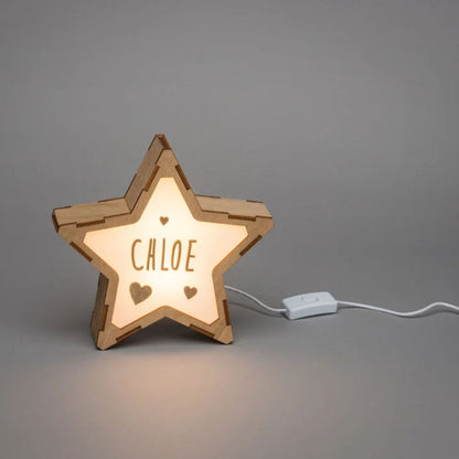 Wooden star-shaped lamp with 'Chloe' on a gray background