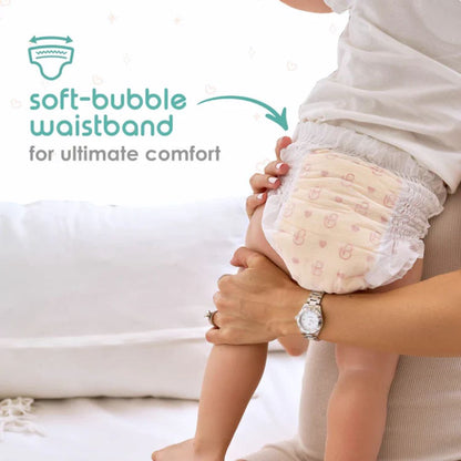 Baby wearing a diaper with a soft-bubble waistband, labeled for ultimate comfort.