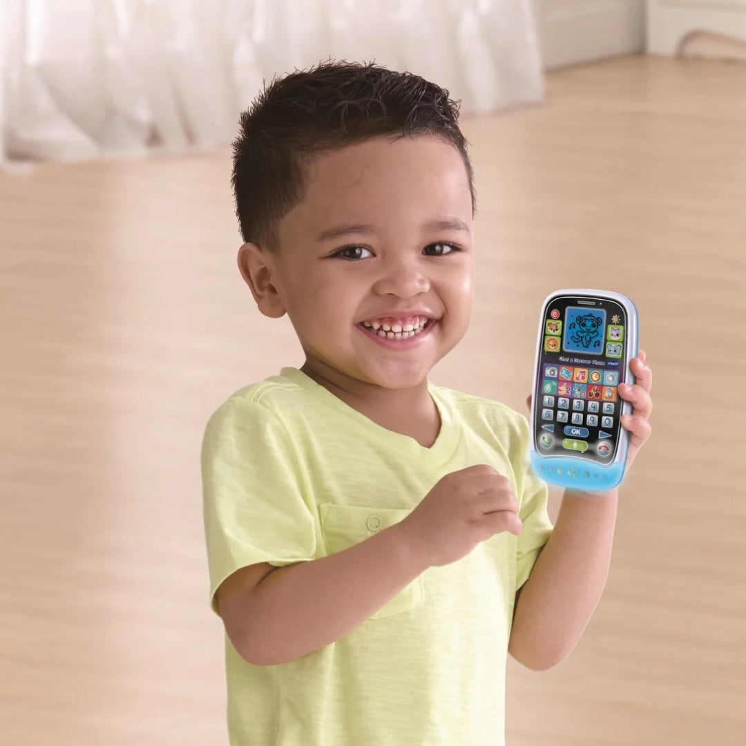 Child holding a Vtech toy phone with a smiling expression