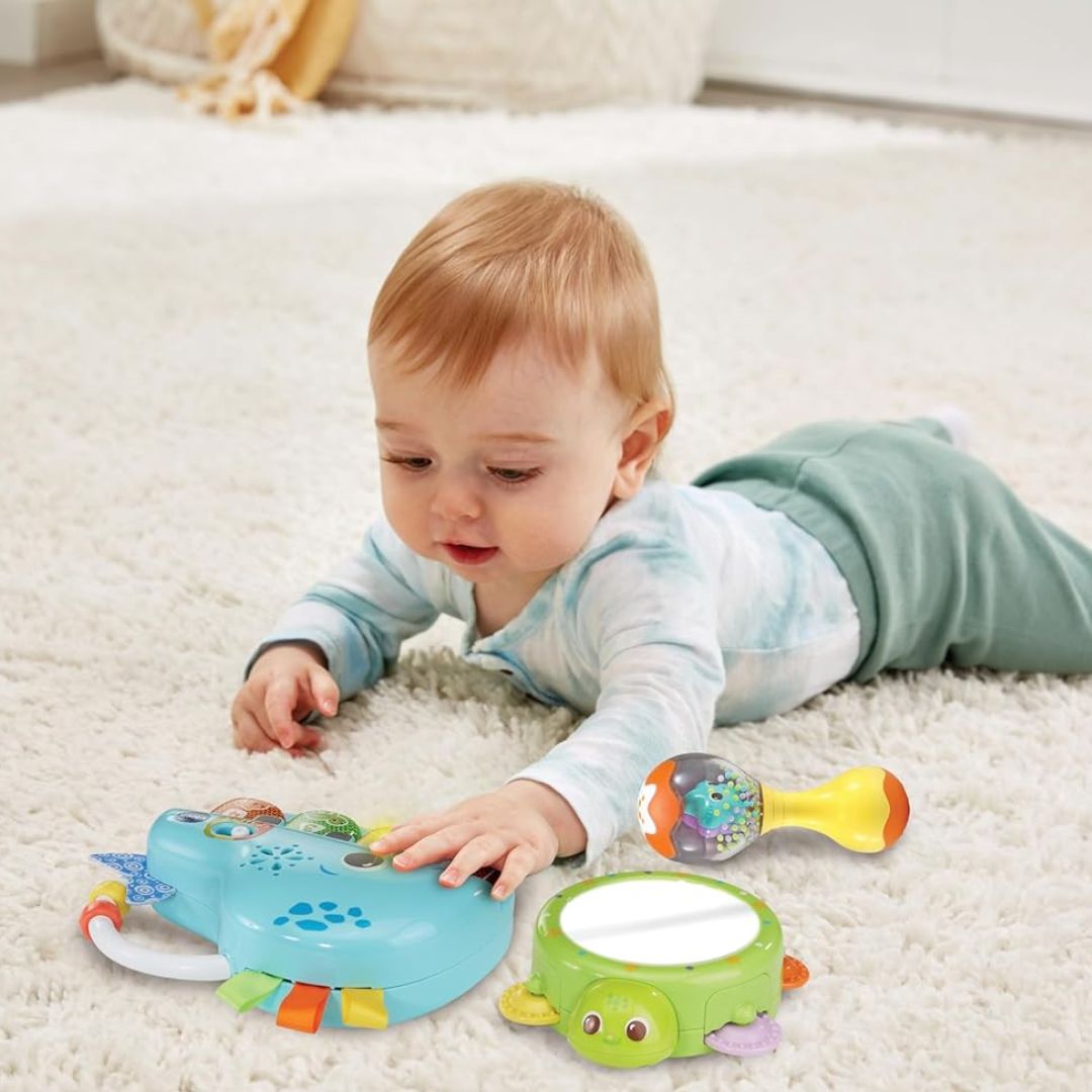Baby playing with colorful vtech toys on a carpeted floor