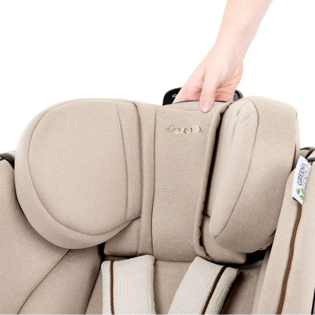 Evenflo Beige car seat with a hand holding onto it, featuring the Cariboo brand.