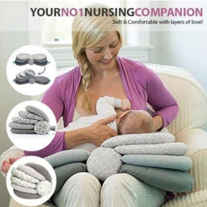 Woman breastfeeding a baby with nursing pillows and accessories displayed around her.