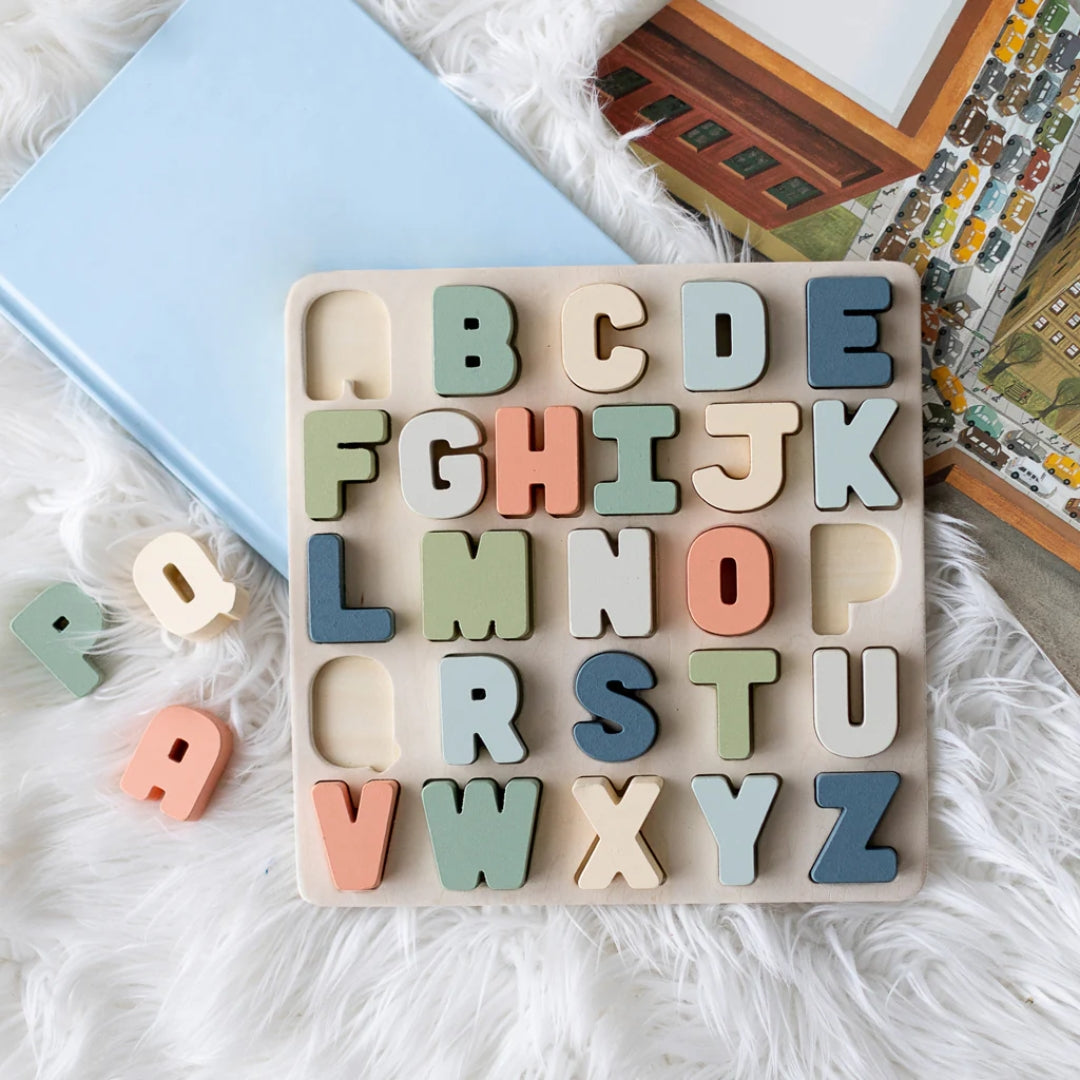 Pearhead Wooden alphabet puzzle with colorful letters on a soft surface