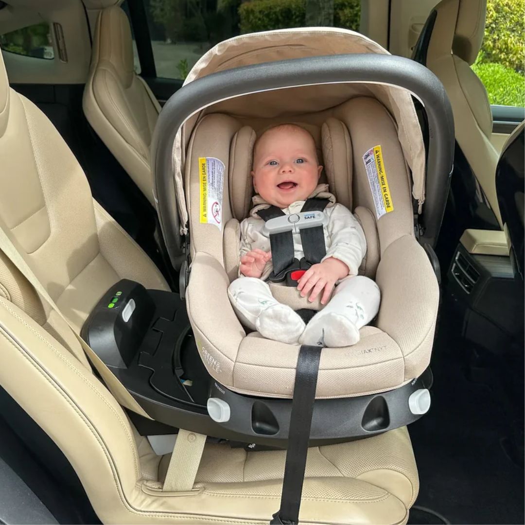 Baby in a beige Evenflo car seat inside a vehicle
