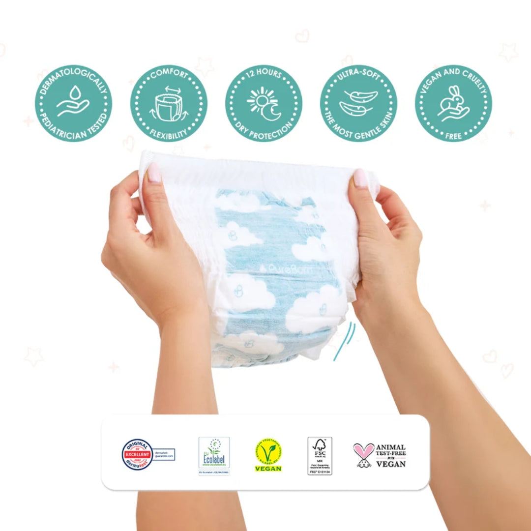 Hands holding a package of diapers with multiple certification logos on a white background