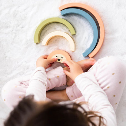 Child playing with colorful Pearhead wooden toys on a soft surface