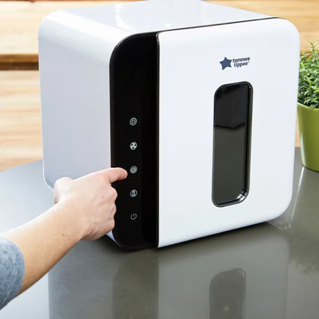 White and black UV Sterilizer with a hand interacting with it on a reflective surface.