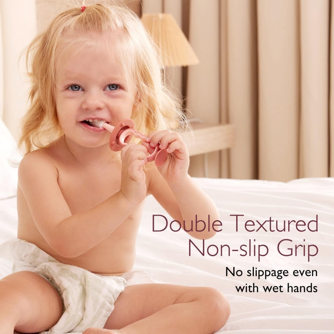Child holding a pink momcozy toothbrush with text about double textured non-slip grip