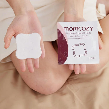 Person holding a Momcozy hydrogel breast pad and its packaging.